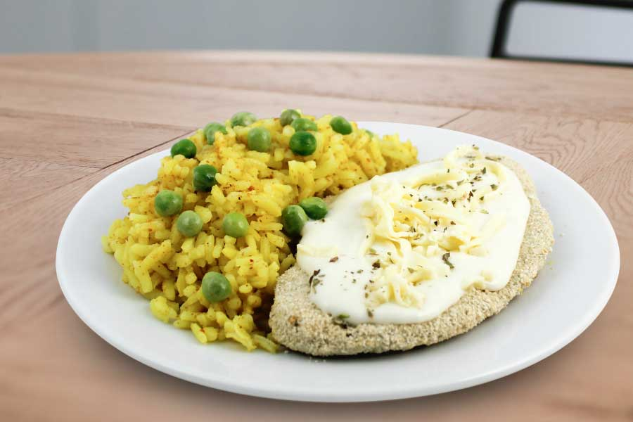 Milanesa de pollo a la suiza con arroz al curry y arvejas